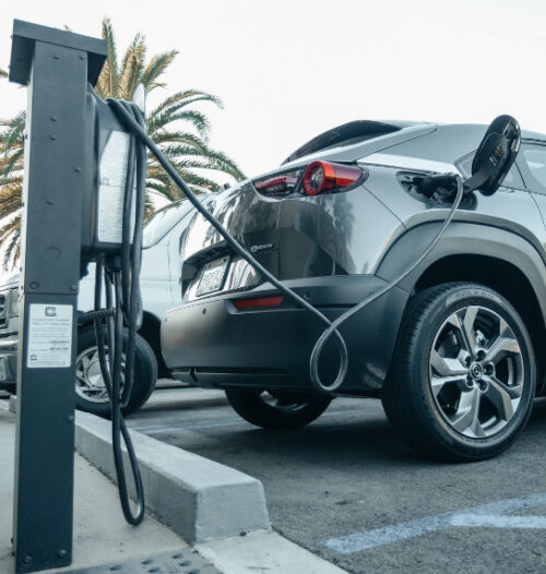 grey car plugged into ev charging point in outside carpark