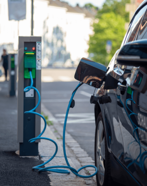 car plugged into EV charging point in street