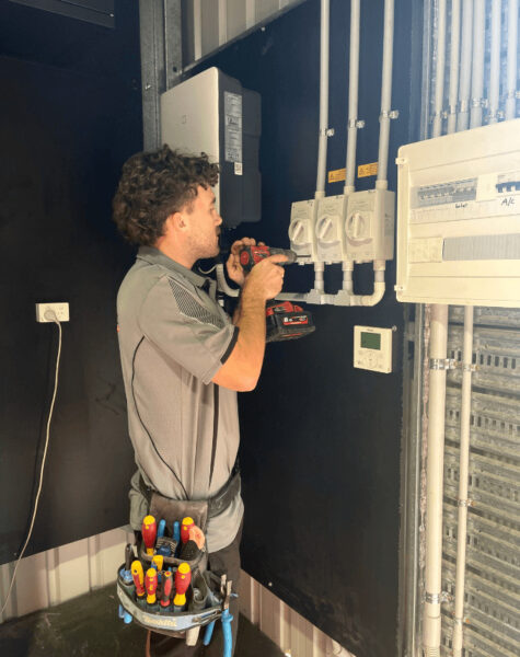 solar technician using drill to install electrical points