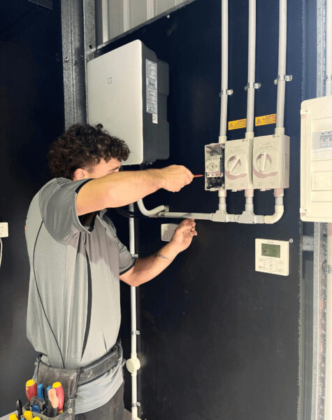 electrician using screw driver to secure power point unit