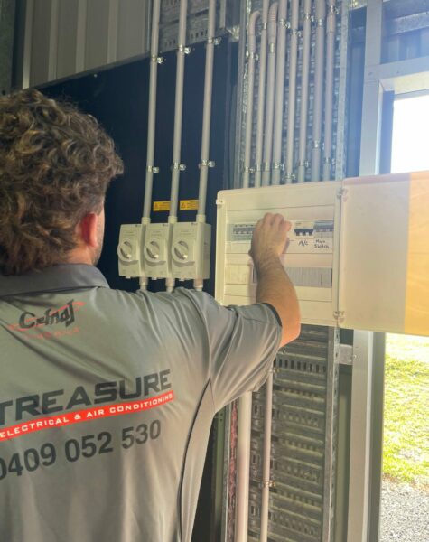 electrician with hand on electrical switchboard